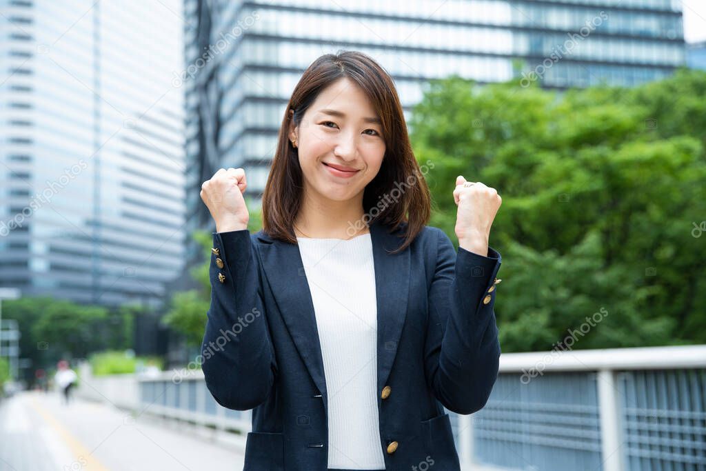 Asian (Japanese) female office worker posing strongly with both hands