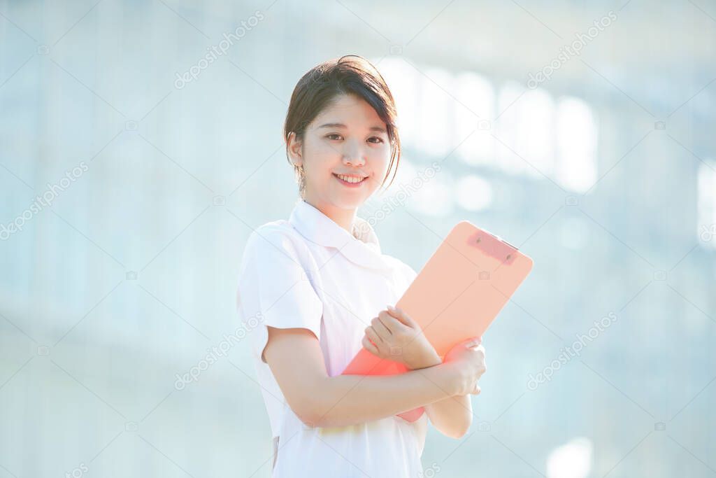 Portrait of an Asian (Japanese) female nurse showing a smile outdoors