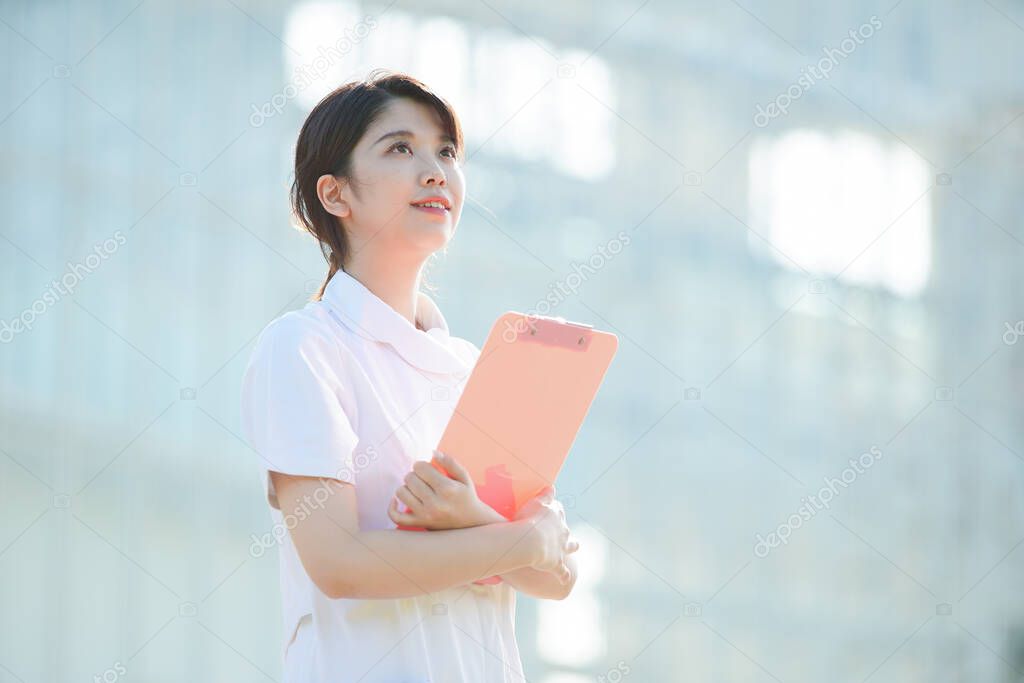 Portrait of an Asian (Japanese) female nurse showing a smile outdoors