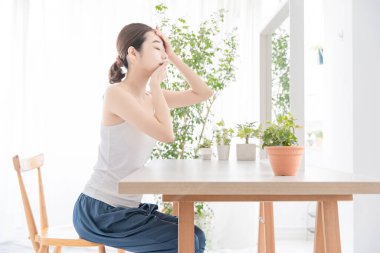 Parlak bir odada kendi cildini yapan Asyalı genç bir kadın.