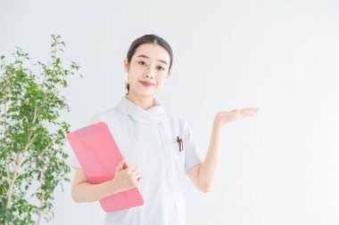 Kapalı alanda gülümseyen bir Asyalı (Japon) kadın hemşire portresi