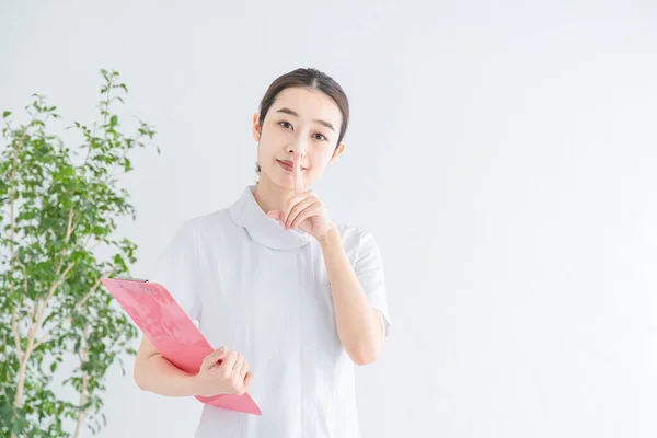 Asyalı Japon Kadın Hemşire Işaret Parmağını Ağzında Tutuyor — Stok fotoğraf