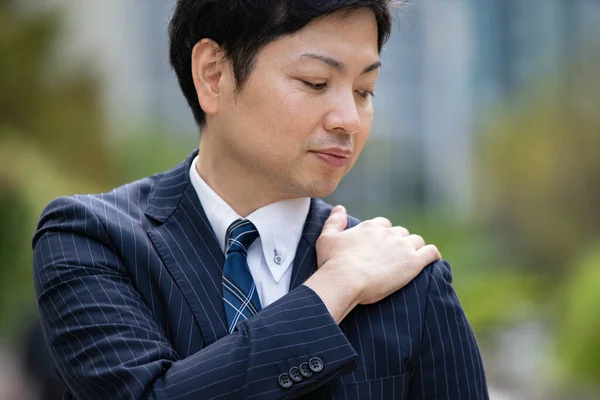 Ung Asiatisk Affärsman Som Håller Hand Med Smärta Axeln Utomhus — Stockfoto