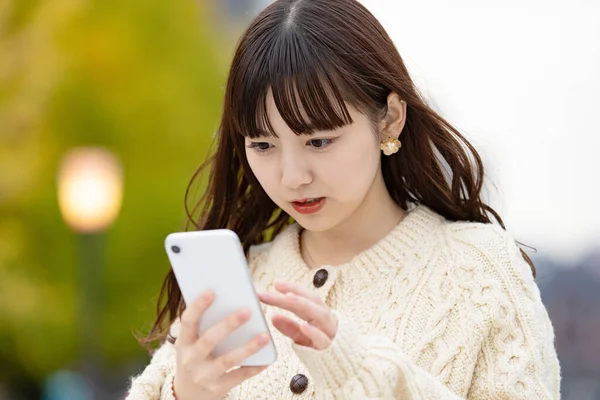 Asiático Japonês Jovem Mulher Operando Smartphone Com Olhar Inquieto — Fotografia de Stock