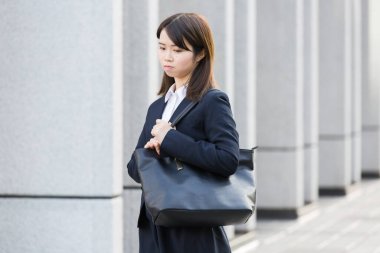 Asyalı (Japon) genç bir bayan çalışanın sıkıntılı bir ifadesi var.