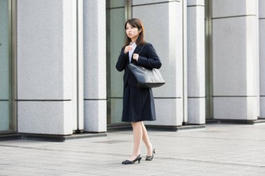 Asyalı (Japon) genç bir bayan çalışanın sıkıntılı bir ifadesi var.