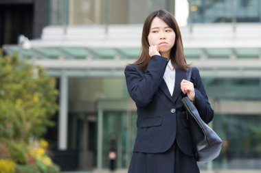 Asyalı (Japon) genç bir bayan çalışanın sıkıntılı bir ifadesi var.