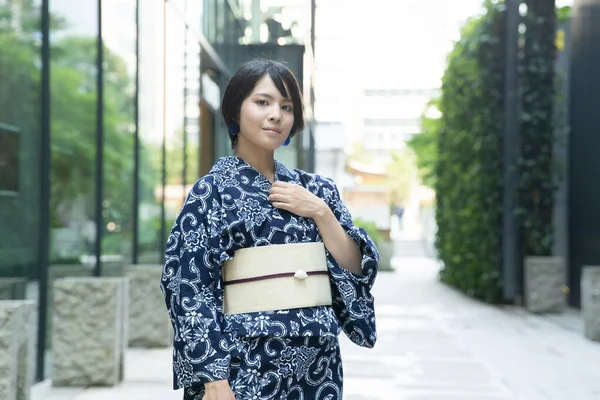 Asian (Japanese) woman going to town wearing a yukata (Japanese traditional costume)