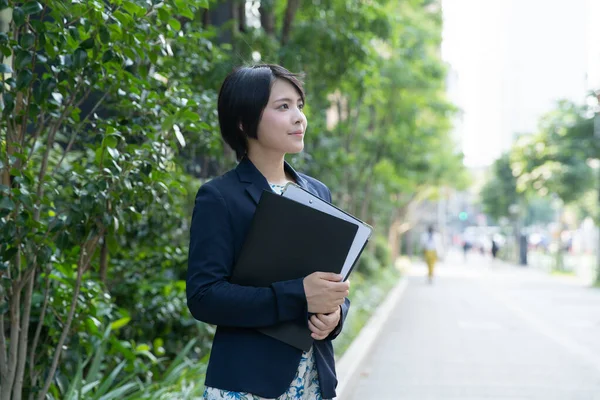 Portrait of young Asian (Japanese) business woman in business district