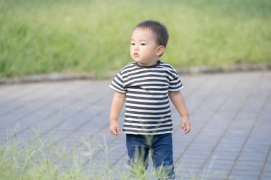 İki yaşındaki çocuk ve annesi güneşli bir günde parkta oynuyorlar.