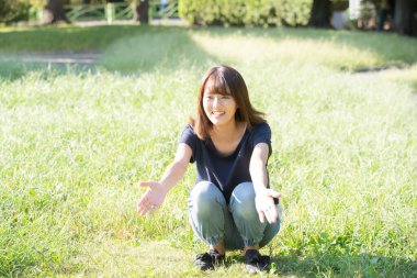 İki yaşındaki çocuk ve annesi güneşli bir günde parkta oynuyorlar.