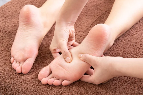 亚洲女性医生按摩女性病人的脚掌 — 图库照片