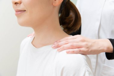 Asyalı kadın pratisyen doktor kadın hasta omuzları ve boynu.