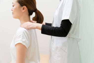 Asyalı kadın pratisyen doktor kadın hasta omuzları ve boynu.