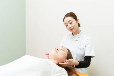 Asyalı kadın pratisyen doktor kadın hasta omuzları ve boynu.