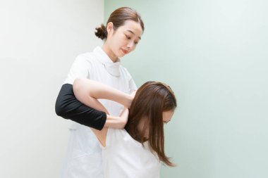 Asyalı kadın pratisyen doktor kadın hasta omuzları ve boynu.