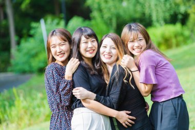 Gülümseyen ve hatıra fotoğraflarına sığan dört Asyalı (Japon) genç kadın