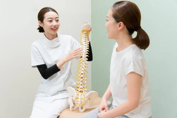 Asiatische Ärztin Hört Sich Symptom Einer Patientin Und Erklärt Behandlungsmethode — Stockfoto