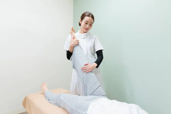 Asiatische Ärztin Massiert Fuß Und Sohle Einer Patientin — Stockfoto