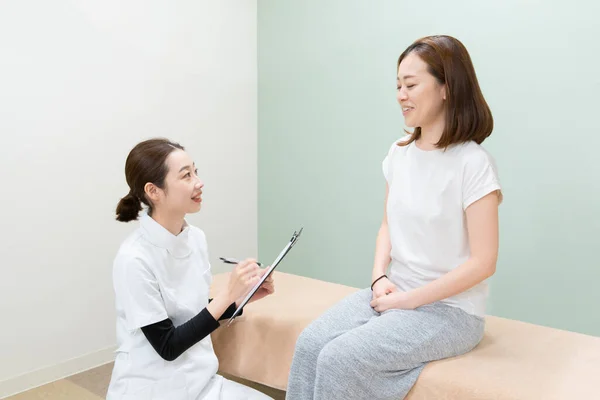 Asiatische Ärztin Hört Sich Symptom Einer Patientin Und Erklärt Behandlungsmethode — Stockfoto