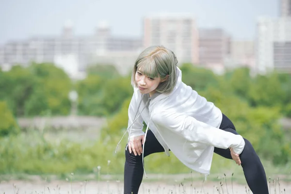 Asyalı Genç Kadın Yeşil Alanda Esneme Egzersizi Yapıyor — Stok fotoğraf