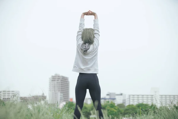 Азиатская Молодая Женщина Делает Упражнения Растяжку Городской Зеленой Зоне — стоковое фото