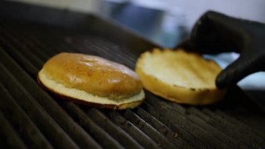 Hamburger pişiriyorum, mutfakta bir aşçı yanıyor.