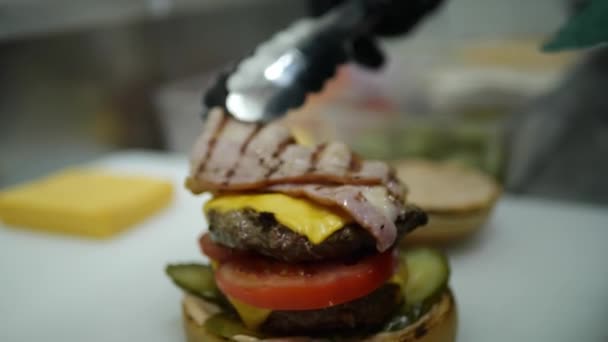 Een hamburger koken, in de keuken staat een kok in brand — Stockvideo