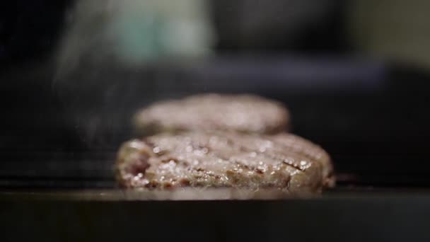 Carne en la estufa, humo de fuego, cocinar una hamburguesa y una hamburguesa cocinera en la cocina — Vídeo de stock