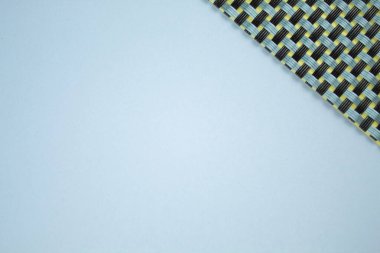 Köşeli gri arka plan. Metin yerleştirmek için ışık arkaplanı uygun. Sağ üst köşede sarı arka planda siyah ve gri çizgili dokulu örgüler var. Katı biçim.