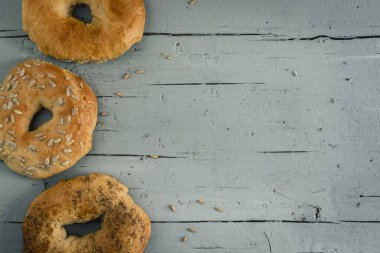 Gri ahşap arka planda üç ev yapımı simit. Kopyalama alanı olan üst görünüm.