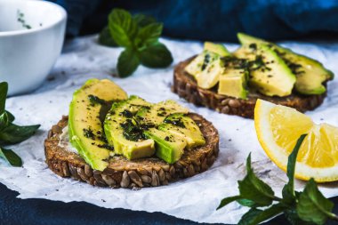 Avokado, pesto, şifalı otlar ve limonlu yuvarlak dilimler. Yakın çekim..