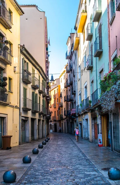 İspanya 'nın Girona şehrinde güneşli bir sabahta renkli evleri olan küçük bir kaldırım. 30 Ağustos 2019.