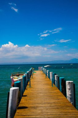 Shore Bardolino, mavi gökyüzü üzerinde ahşap yürüme yolu