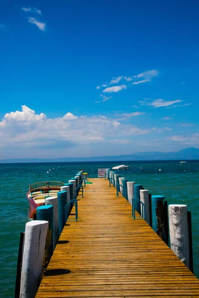 Shore Bardolino, mavi gökyüzü üzerinde ahşap yürüme yolu