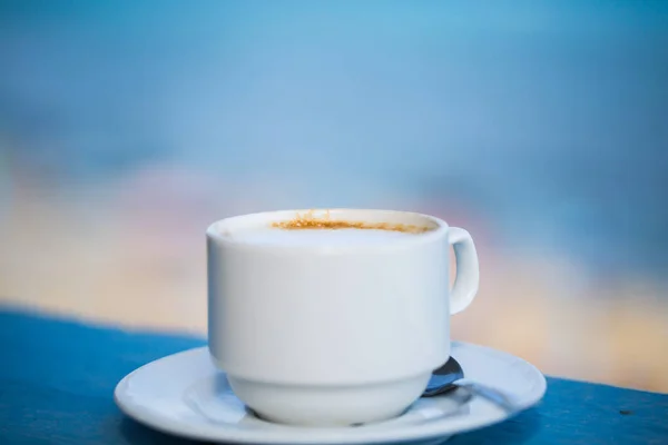 Xícara de cappuccino com vista mar — Fotografia de Stock