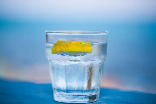 Glas Wasser, blauer Hintergrund — Stockfoto