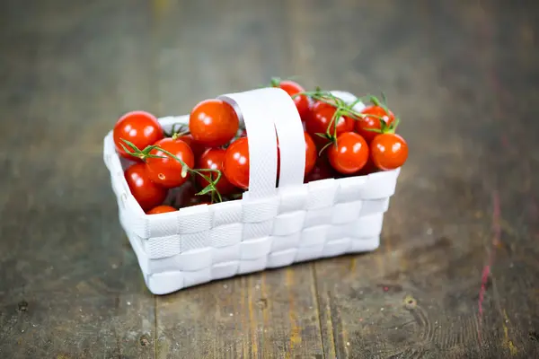 Tomates de cóctel en una cesta, fondo de madera —  Fotos de Stock