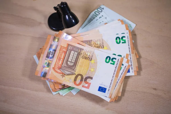 Banconote in euro sotto la lampada da lettura — Foto Stock