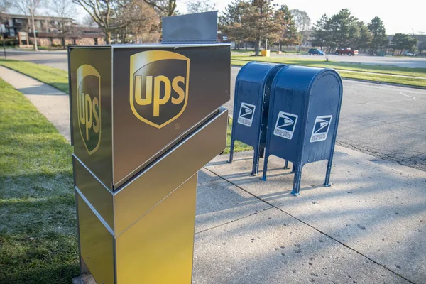Chicago Illinois, ABD - 2020 dolaylarında: Hükümetin özel şirketlere karşı soyut bir temsili. Bir USPS ve UPS, şiddetli rekabet ve rekabetlerini yansıtmak amacıyla bir malikanede gösteriliyor.