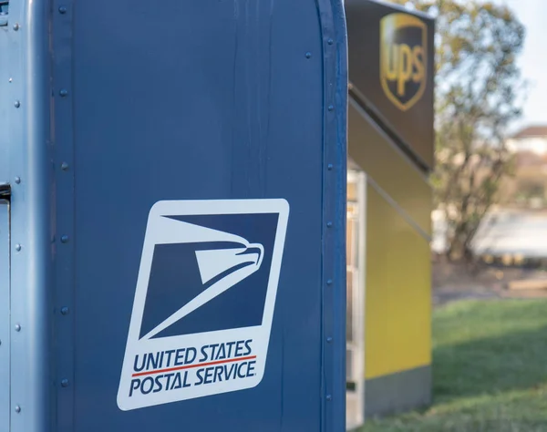 Chicago Illinois, ABD - 2020 dolaylarında: Hükümetin özel şirketlere karşı soyut bir temsili. Bir USPS ve UPS, şiddetli rekabet ve rekabetlerini yansıtmak amacıyla bir malikanede gösteriliyor.