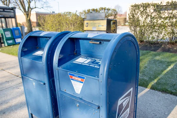 Chicago Illinois, ABD - 2020 dolaylarında: Hükümetin özel şirketlere karşı soyut bir temsili. Bir USPS ve UPS, şiddetli rekabet ve rekabetlerini yansıtmak amacıyla bir malikanede gösteriliyor.
