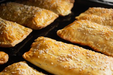 Pişirme tepsisinde ev yapımı etli turtalar.