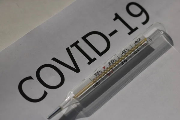 Beyaz arkaplanda termometreyle siyah ovid 19 yazılıydı.