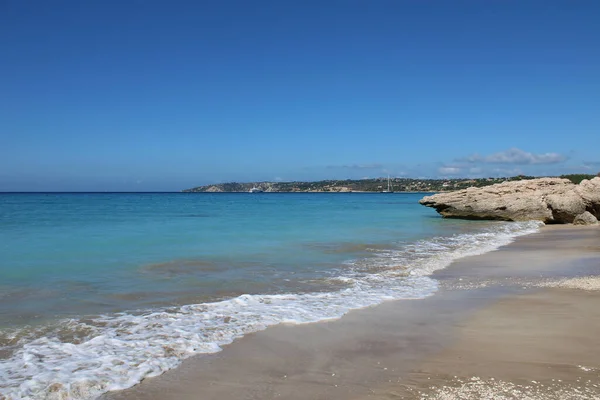 Beautiful sea view of the beach with waves and rocks.