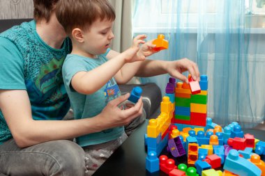 Baba ve oğul inşaatçıda oynuyor. Covid-19 'la savaşmak için kendini izole etme kavramı