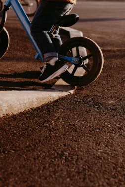 Bir çocuk dengeleyici bisiklet sürüyor. Etkin yürüyüş