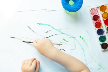 Yaratıcı çocuk, odasında resim yapıyor. Anaokulu çocukları için eğitici oyunlar