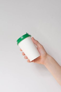 Arka plandaki kahve fincanını kaldır. Elinde kahve fincanı tutan bir erkek. 