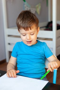 Yaratıcı çocuk, odasında resim yapıyor. Anaokulu çocukları için eğitici oyunlar